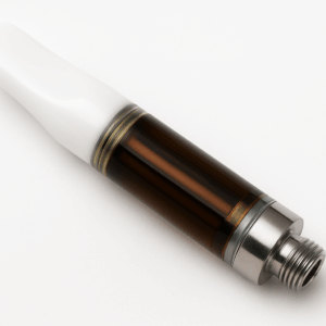 Eine Nahaufnahme der THC Vape 65% Haze 0,5mL Patrone mit weißem Mundstück, transparenter, mit dunklem Cannabisextrakt gefüllter Kammer und Metallgewindeboden, fotografiert auf weißem Hintergrund.